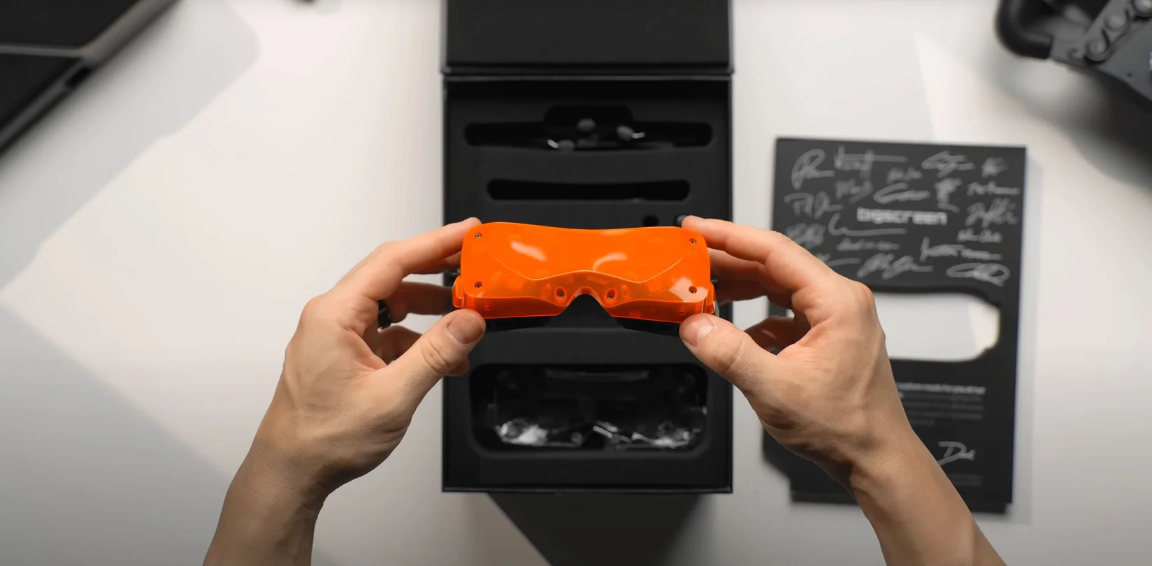 Creator unboxing a translucent orange Bigscreen Beyond headset